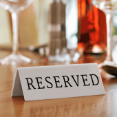 Each reserved table sign is made from white acrylic with black print