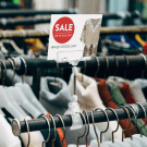 Plastic clip on sign holders displaying promotions on a clothes rail