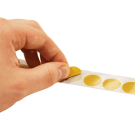 Sticky dots being peeled from a reel for convenience