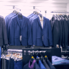 Slatwall paneling fitted with clothes rails in a suit shop 