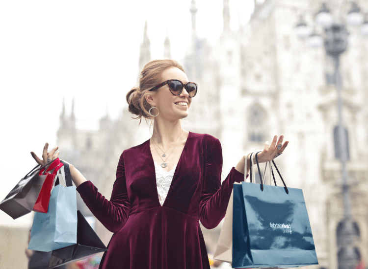 Woman carrying branded shopping bags with company logo signs - why are logos important for business?