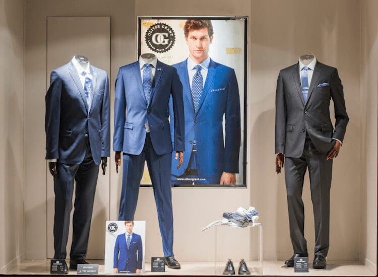 Window display of a men's fashion retailer with an illuminated poster