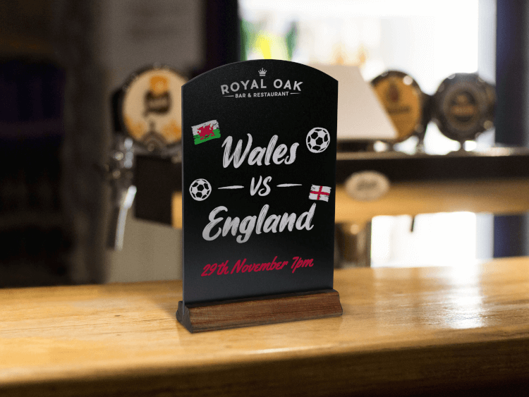 tabletop chalkboard sign displaying a world cup match time