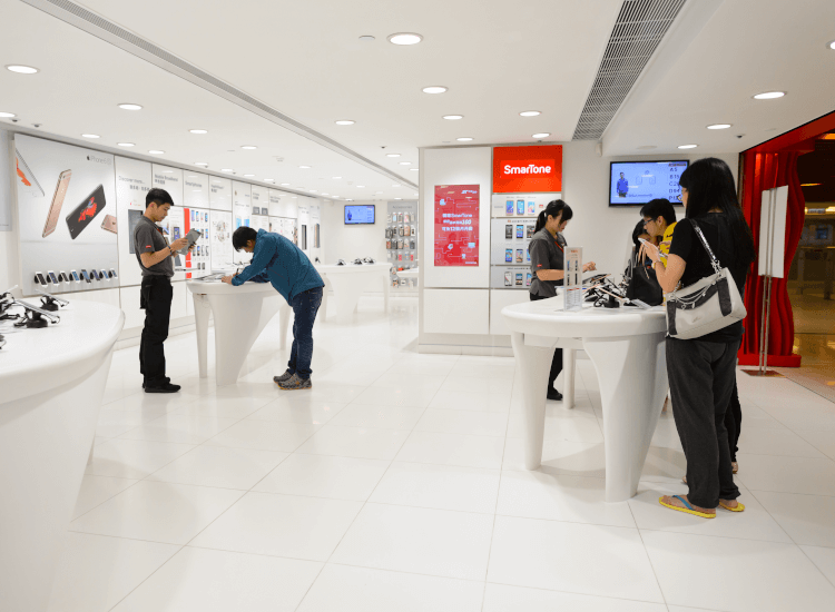 Customers in a technology store examining products on display